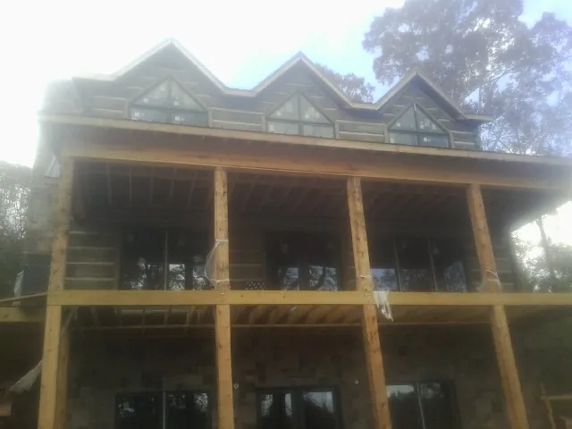Dormers and porch framing on a large log home under construction — Roof Coating work by our crew in Pendleton