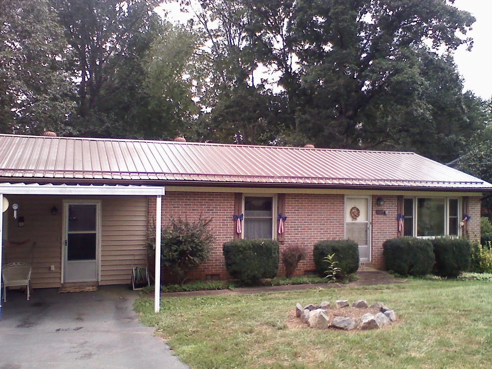 Bronze metal roof and carport on a brick ranch home — Roof Repair work by our crew in Pendleton